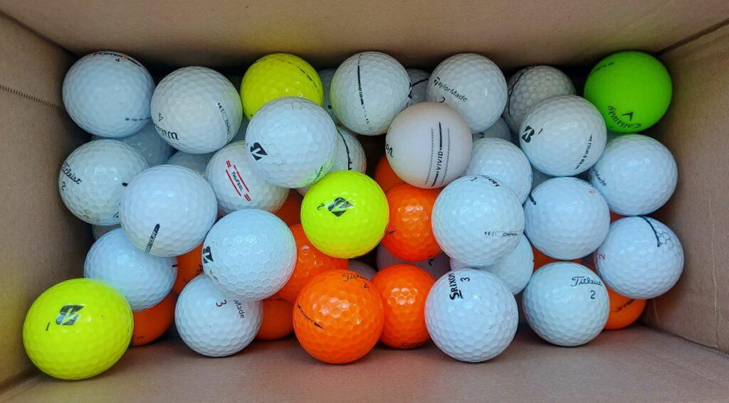 a box with a bunch of used golf balls