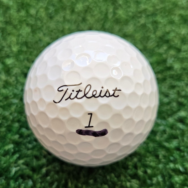 Titleist AVX golf ball with a short line drawn under the number